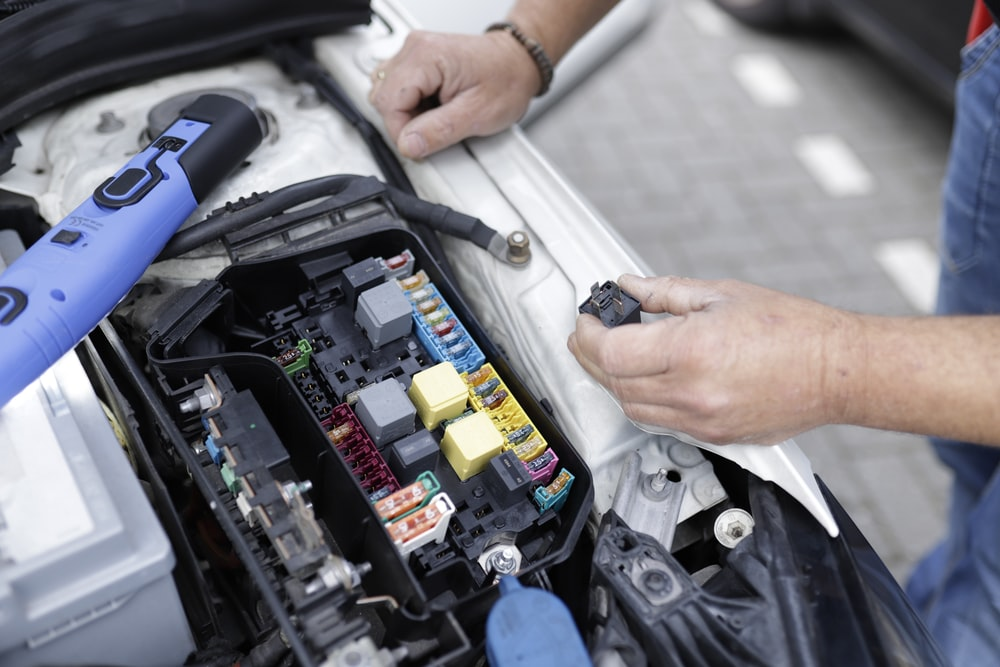 A mechanic working on a car’s electronics