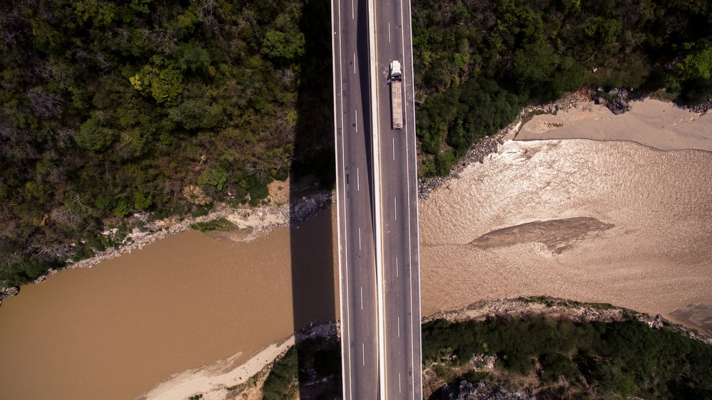 An aerial view of a truck crossing a bridge