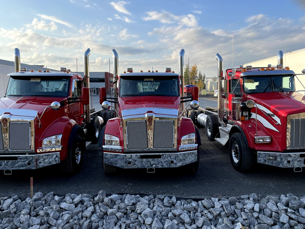 Three red trucks parked next to one another