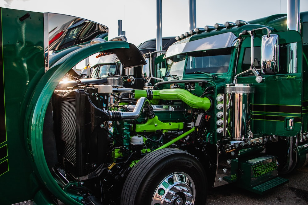 Exposed under-hood of a green truck.
